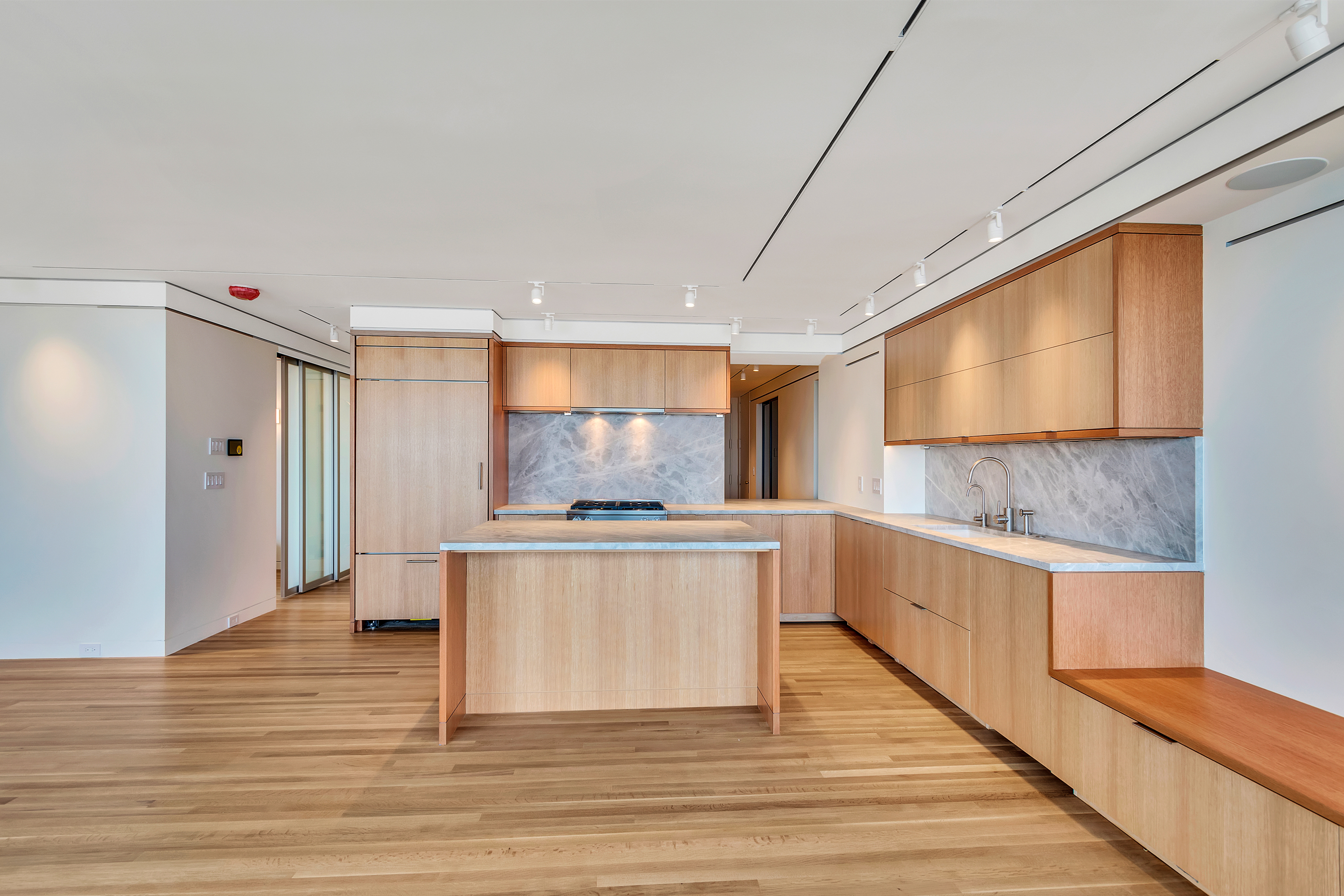 Boston Harbor Flat kitchen with warm wood cabinetry and stone surfaces