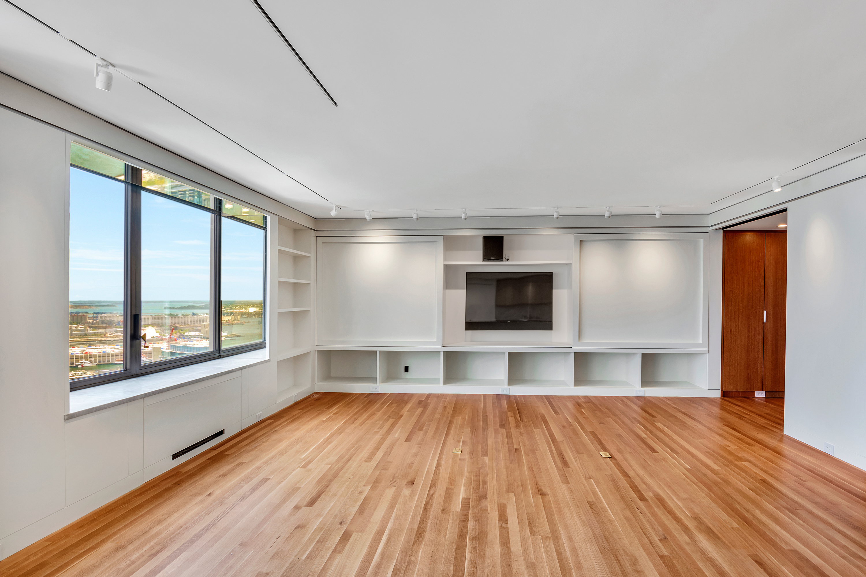 Harbor-facing living room with built-in cabinetry and fireplace