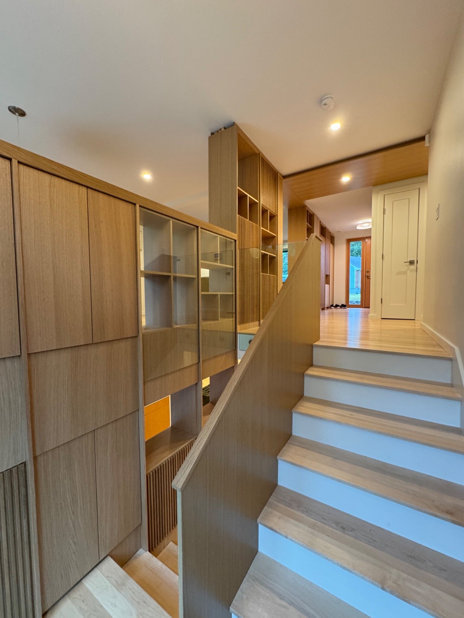 Custom built-in cabinetry alongside an oak staircase