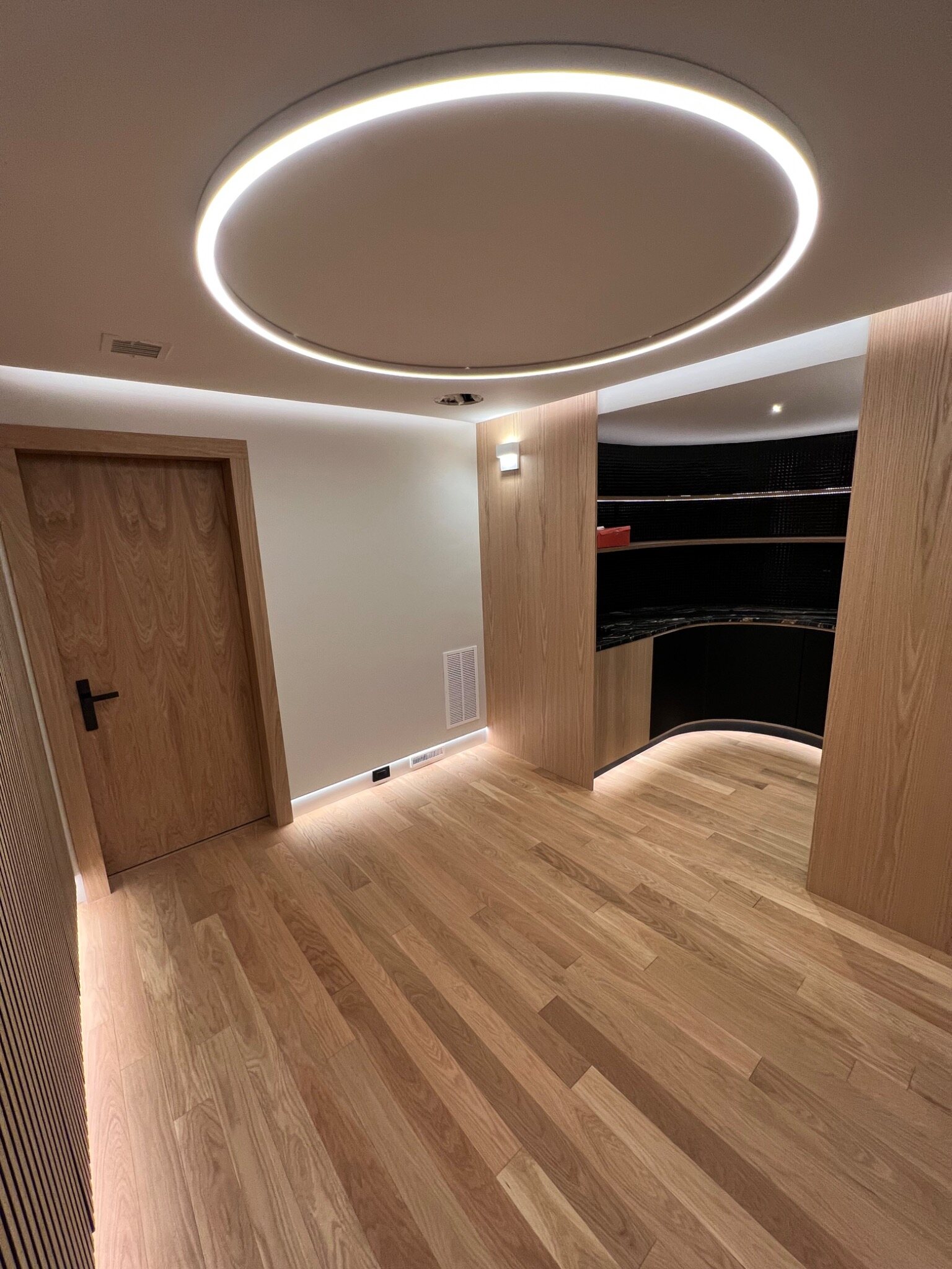 Custom oak paneling with architectural lighting