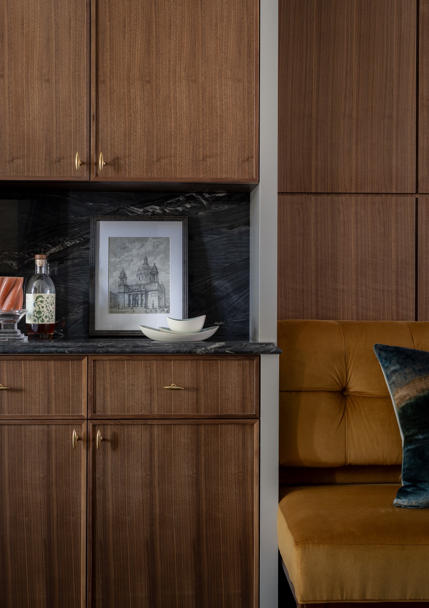 Detail of custom walnut cabinetry with brass hardware